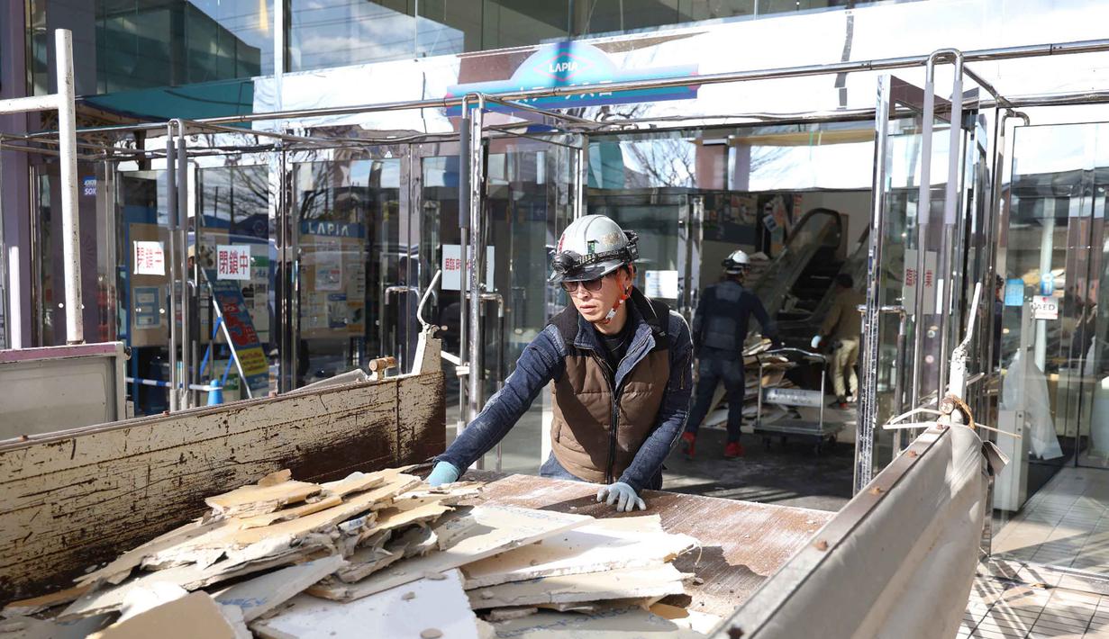 Gempa yang melanda Prefektur Aomori bagian utara yang memicu peringatan tsunami di sepanjang pantai timur laut Pulau Honshu dan pantai timur Pulau Hokkaido. Tampak dalam foto, seorang pekerja membersihkan puing-puing di pusat perbelanjaan yang rusak akibat gempa bumi di Kota Hachinohe, Prefektur Aomori, Jepang, pada Selasa 9 Desember 2025. (JIJI Press/Japan OUT/AFP)
