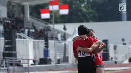 Pelari difable Indonesia, Nurhaida Insan (kanan) dipeluk rekannnya usai berlaga di kelas Womens 100m T36/37/38 Indonesia Para Games Invitational Tournament 2018 di Stadion Madya Senayan, Jakarta, Minggu (1/7). (Liputan6.com/Helmi Fithriansyah)