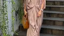 Nadia Mulya mengenakan kaftan warna coklat shimmer yang memiliki aksen beads di bagian kerah model v neck. Kaftan tersebut semakin menarik dengan model cut out di pundak. [@nadiamulya]
