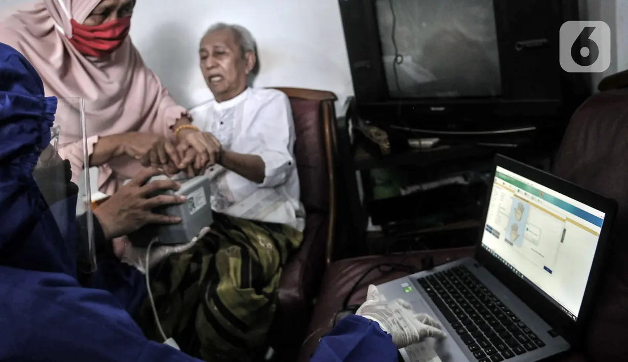Petugas Disdukcapil Kota Jakarta Utara merekam E-KTP penyandang disabilitas di Pademangan Barat, Jakarta, Kamis (16/7/2020). Program jemput bola ini untuk memudahkan pelayanan administrasi kependudukan bagi penyandang disabilitas, jompo dan orang sakit di masa pandemi. (merdeka.com/Iqbal S. Nugroho)