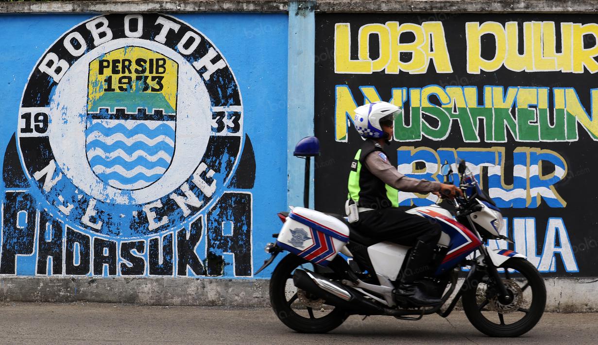 Polisi melintas dekat mural kreasi Bobotoh di Bandung, (16/7/2016). (Bola.com/Nicklas Hanoatubun)