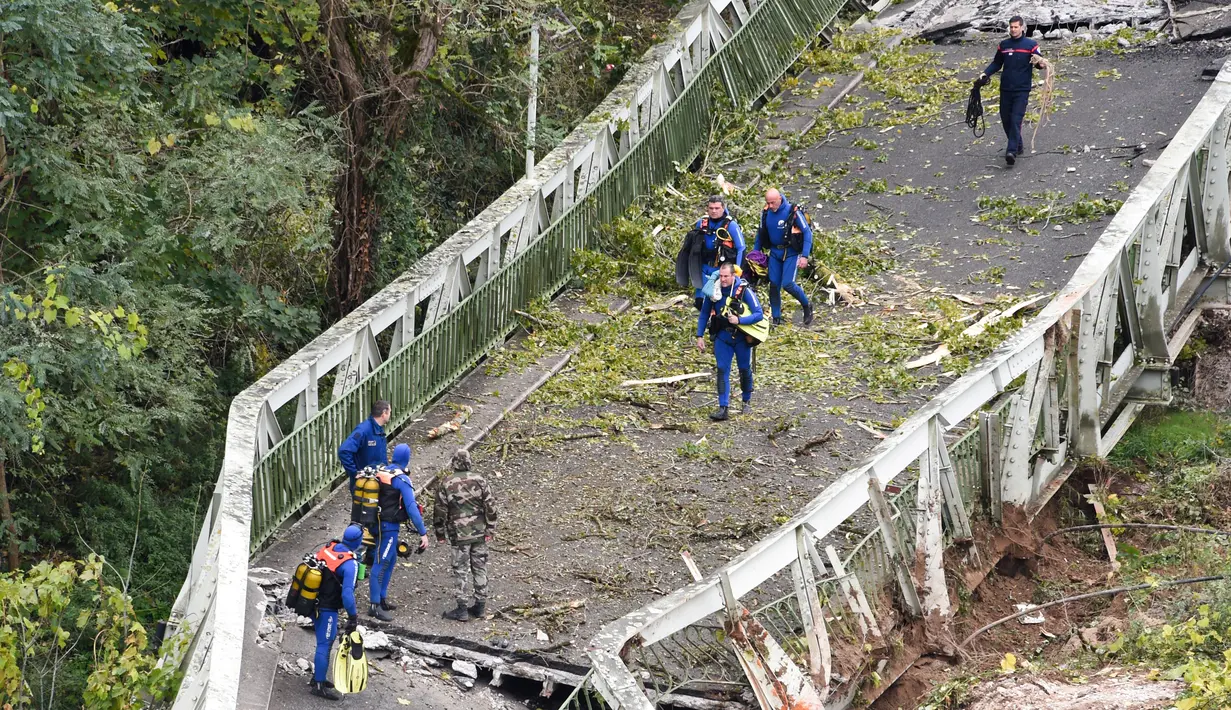 Tim penyelamat berjalan di atas jembatan gantung yang ambruk di atas sungai Tarm, Prancis, Selasa (18/11/2019). Jembatan gantung yang menghubungkan kota Mirepoix-sur-Tarn itu tiba-tiba ambruk hingga menyebabkan seorang gadis berusia 15 tahun dan satu sopir truk tewas. (ERIC CABANIS/AFP)