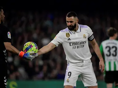 Penyerang Real Madrid, Karim Benzema mengambil bola saat bertanding melawan Real Betis pada pertandingan La Liga Spanyol di stadion Benito Villamarin di Seville, Senin (6/3/2023). Di laga ini gol Benzema di menit 12 sempat dianulir VAR dan Los Blancos hanya mampu bermain imbang tanpa gol dengan Real Betis. (AFP/CRISTINA QUICLER)