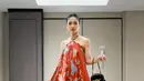 Andien Aisyah tampil dibalut dress motif batik bunga warna merah dengan gaya halterneck. Dipadukan tas hitamnya. [@andieaisyah]