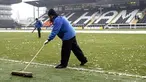 Ground staff try to clear ice from the pitch before Fulham's Premier League match against Blackburn at Craven Cottage, London, on January 10, 2009. AFP PHOTO / Glyn Kirk