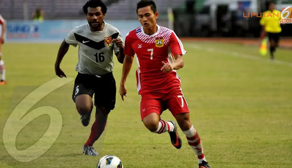 Pemain Laos, Khonesavanh Sihavong (nomor 7) berebut bola dengan pemain Papua Nugini Sengum Maximilion saat bertanding yang digelar Minggu (24/11/13) di GBK, Jakarta (Liputan6.com/Helmi Fithriansyah)