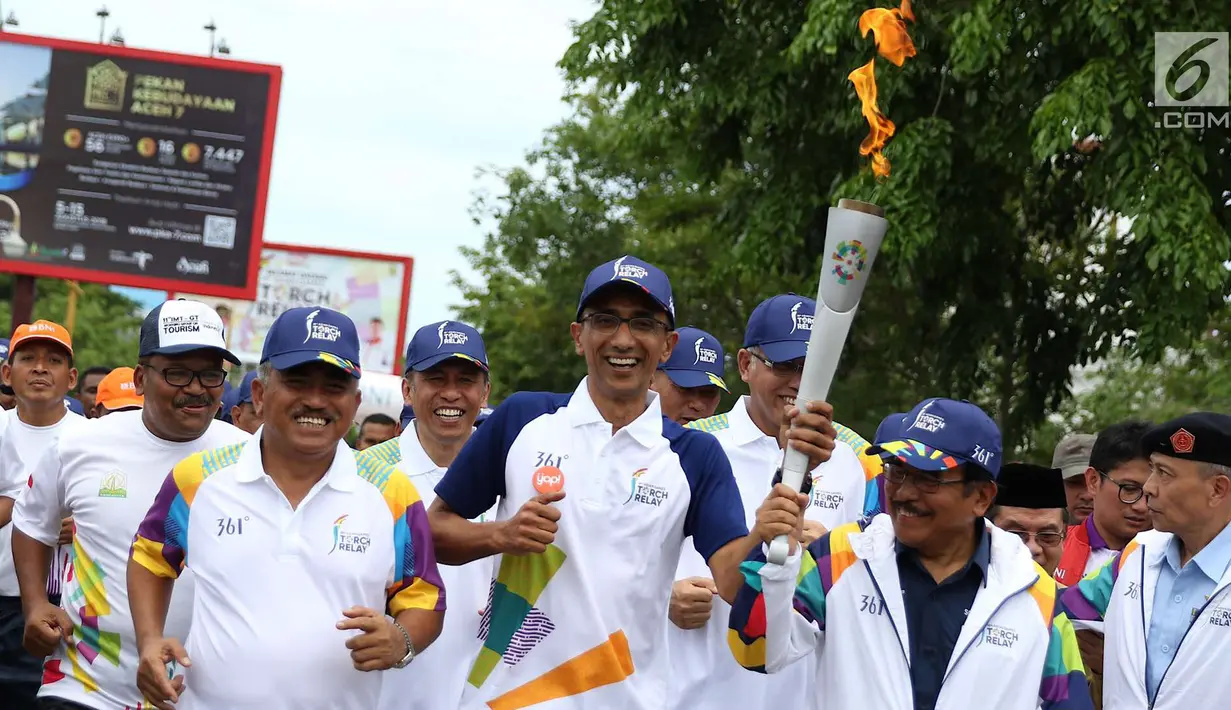 Menteri Agraria dan Tata Ruang Republik Indonesia Sofyan Djalil bersama Komisaris BNI Ahmad Fikri Assegaf saat kirab Obor (torch relay) Asian Games di Banda Aceh, Selasa (31/7). (Liputan6.com/Immanuel Antonius)