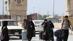 Sejumlah warga Pakistan melintasi perbatasan Taftan pada Selasa 3 Maret 2026. Tampak dalam foto, warga Pakistan berjalan melintasi perbatasan Taftan di provinsi Balochistan, Iran pada Selasa 3 Maret 2026, di tengah serangan Amerika Serikat dan Israel yang terus memanas. (Banaras KHAN/AFP)