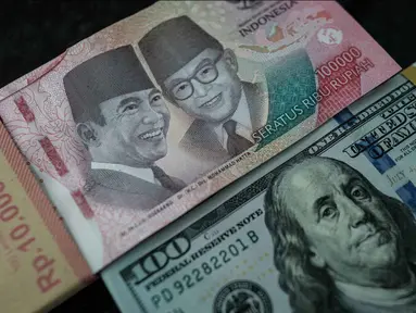 Uang kertas Rp 100.000 diletakkan berdampingan dengan uang dolar Amerika Serikat di salah satu kantor penukaran, Jakarta, Kamis pada 4 Juni 2026. (Yasuyoshi Chiba/AFP)
