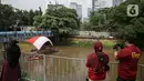 Warga menyaksikan pembentangan bendera Merah Putih di aliran kali
Ciliwung di kawasan Sudirman, Jakarta, Minggu (22/8/2021). Pembentangan atau pengibaran bendera Merah Putih tersebut dilaksanakan untuk memperingati HUT ke-76 RI. (Liputan6.com/Faizal Fanani)