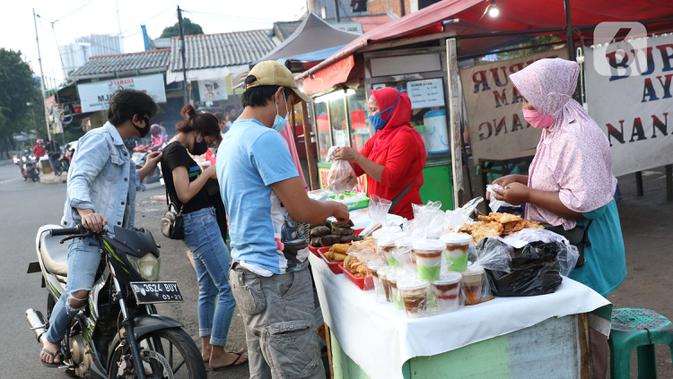Warga melakukan aktivitas jual beli makanan untuk berbuka puasa (takjil) di kawasan Jalan Panjang, Jakarta, Selasa (5/5/2020). Pandemi virus COVID-19 dan pelaksanaan Pembatasan Sosial Berskala Besar (PSBB) berimbas pada sepinya pembeli takjil di kawasan tersebut. (Liputan6.com/Helmi Fithriansyah)