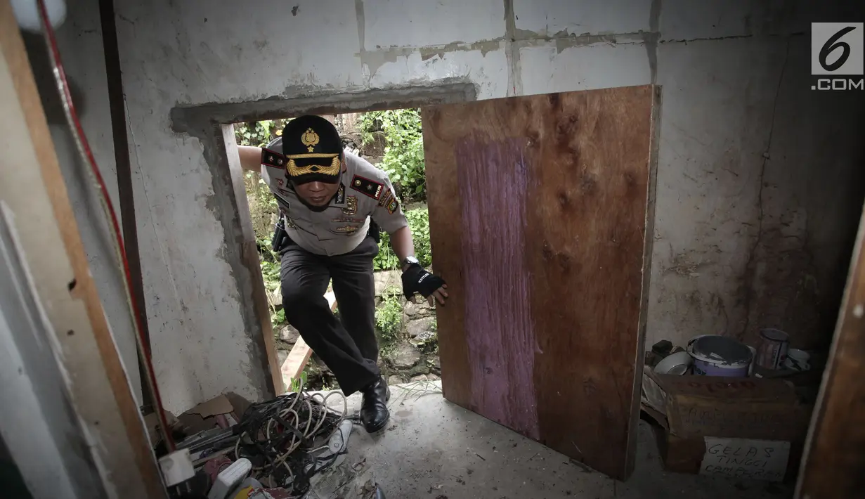 Petugas polisi memeriksa sudut rumah lokasi penggerebekan peredaran narkoba di Kampung Ambon, Jakarta, Rabu (24/1). Satu pelaku lainnya berhasil melarikan diri saat dilakukan penggerebekan dan dalam pengejaran polisi. (Liputan6.com/Arya Manggala)