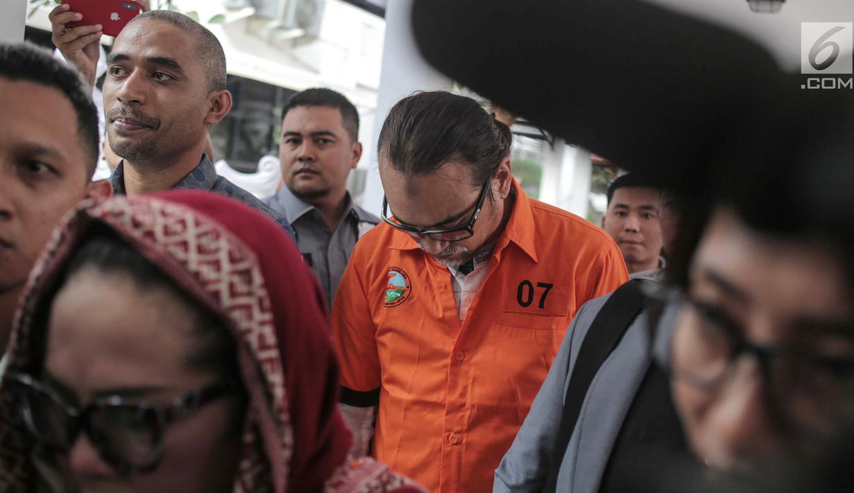 Suami komedian Tri Retno Prayudati alias Nunung, July Jan Sambiran tertunduk saat akan rilis kasus narkoba di Ditnarkoba Polda Metro Jaya, Jakarta, Senin (22/7/2019). Sambiran ditangkap bersama Nunung usai bertransaksi narkoba dengan tersangka TB di kediaman mereka. (Liputan6.com/Faizal Fanani)