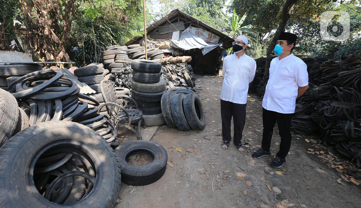 Anggota Komisi XI DPR RI Kamrussamad bersama warga saat melihat ban bekas yang akan diproduksi untuk UMKM di Juanda Depok, Jawa Barat, Selasa (20/7/2021). Pada penerapan kebijakan PPKM Darurat, Kamrussamad berharap terus mendorong usaha kecil di masa pandemi. (Liputan6.com/HO/Bon)
