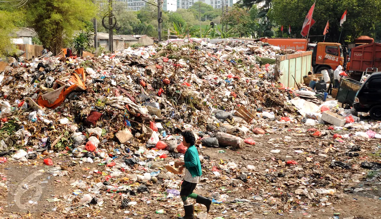 Warga melintas di dekat tumpukan sampah yang ada di Tempat Pembuangan Sampah Sementara Kalibata, Jakarta, Rabu (4/11/2015). Penumpukan sampah terkait aksi pemblokadean jalan menuju TPST Bantar Gebang. (Liputan6.com/Helmi Fithriansyah)