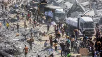 Pasca pemberlakukan kesepakatan gencatan senjata antara Israel dan Hamas pada Jumat 10 Oktober 2025, warga memadati kawasan Khan Younis untuk mengumpulkan bantuan yang masuk melalui pos perbatasan Karem Abu Salem, bagian selatan Jalur Gaza, pada Minggu 12 Oktober 2025. (Omar AL-QATTAA/AFP)