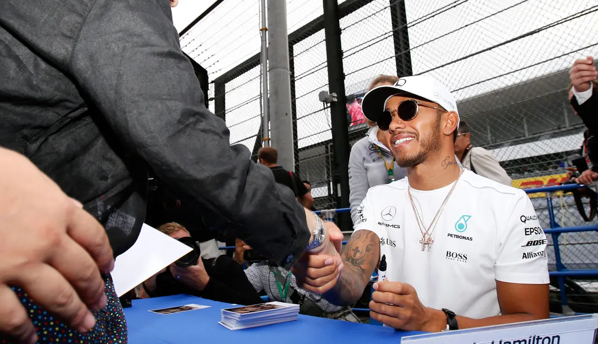 Pembalap Mercedes Lewis Hamilton bersalaman dengan penggemar dari Jepang saat jumpa pers jelang Grand Prix F1 di Sirkuit Suzuka, Jepang (5/10). (AP Photo/Toru Takahashi)
