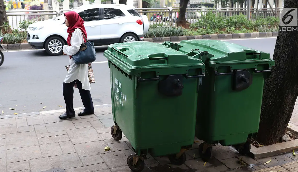 Warga melintas di depan tong sampah asal Jerman di kawasan Kalibata, Jakarta, Selasa (5/6). Gubernur Anies Baswedan mengatakan pengadaan tong sampah ini  bertujuan untuk menunjang truk sampah DKI yang sudah lebih modern. (Liputan6.com/Immanuel Antonius)