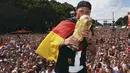Pemain belakang Timnas Jerman, Benedikt Hoewedes, mencium trofi Piala Dunia saat perayaan kemenangan Der Panzer di Berlin, (15/7/2014). (REUTERS/Alex Grimm/Pool) 