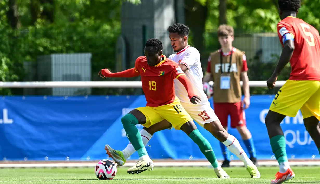 Striker Guinea U-23, Facinet Conte (kiri) menguasai bola dibayangi bek Timnas Indonesia U-23, Bagas Kaffa pada laga play-off antar-konfederasi menuju Olimpiade Paris 2024 di Stade Pierre Pibarot, Centre National du Football de Clairefontaine, Prancis, Kamis (9/5/2024). (AFP/Miguel Medina)