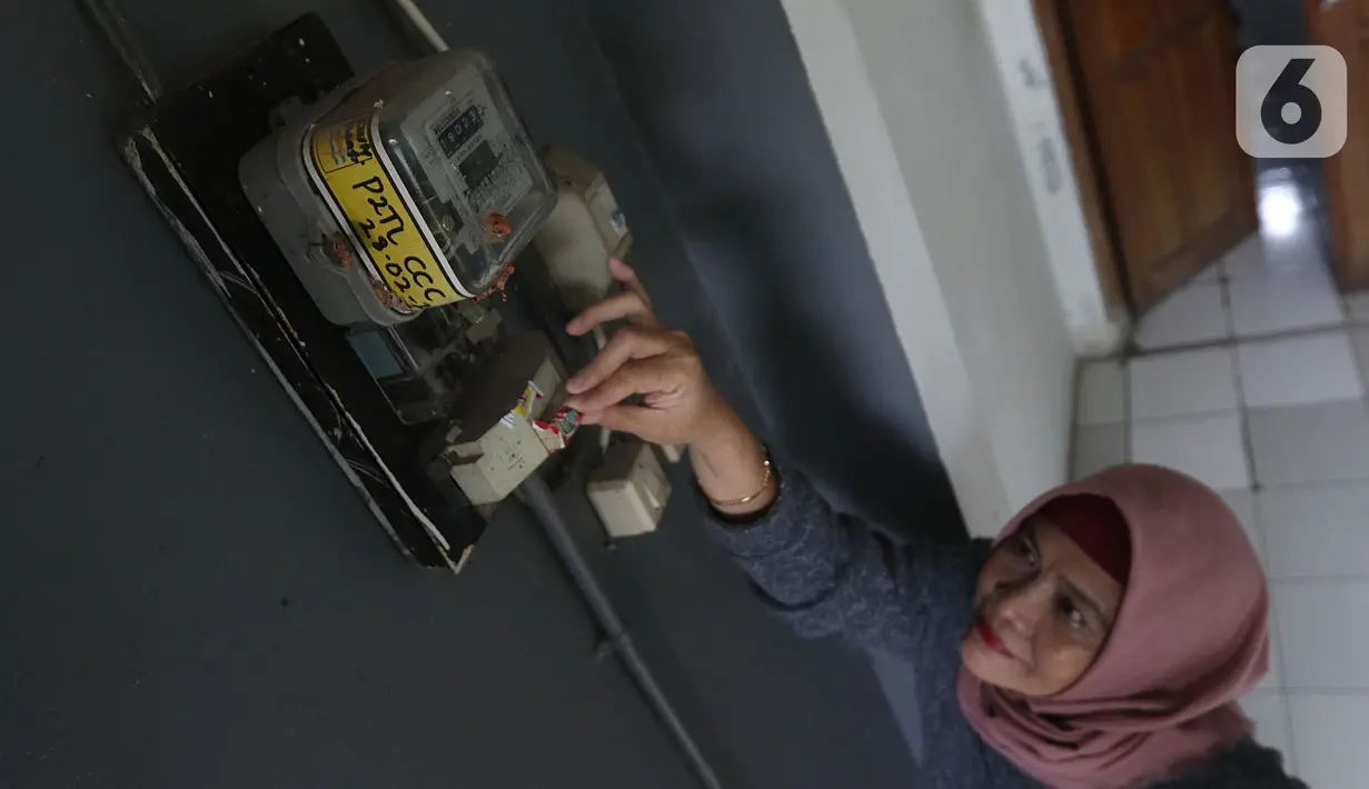 Warga memeriksa meteran listrik di kawasan Matraman, Jakarta, Kamis (2/4/2020). Di tengah pandemi COVID-19, pemerintah menggratiskan biaya tarif listrik bagi konsumen 450 Volt Ampere (VA) dan pemberian keringanan tagihan 50 persen kepada konsumen bersubsidi 900 VA. (Liputan6.com/Herman Zakharia)