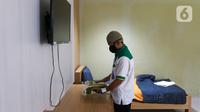 Petugas merapikan salah satu kamar tidur untuk calon jemaah haji di Asrama Haji Pondok Gede, Jakarta, Senin (23/5/2022). Asrama Haji Pondok Gede Jakarta siap melayani calon jemaah haji 1443 H/2022 M, yang dijadwalkan mulai masuk asrama pada 3 Juni 2022 mendatang sebelum keberangkatan menuju Tanah Suci Mekkah dan Madinah di Arab Saudi. (Liputan6.com/Herman Zakharia)