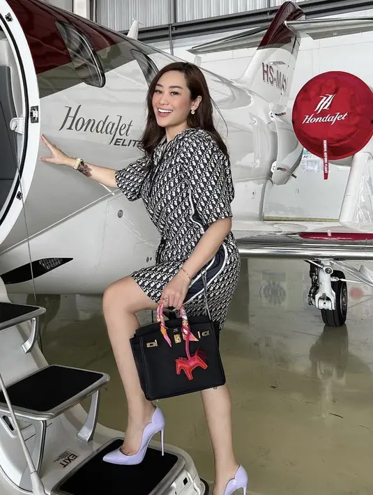 Mengenakan mini dress dari Dior, Poppy memadukannya dengan heels ungu sambil membawa tas Hermes hitam lengkap dengan gantungan kunci kudanya. [Instagram/@poppycapella_]