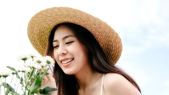perempuan mencium bunga