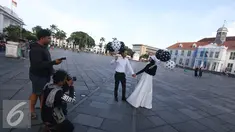 Fotografer mengabadikan foto untuk pranikah di kawasan Kota Tua, Jakarta, Kamis (29/9). Gubernur DKI Jakarta Basuki Tjahaja Purnama memastikan aktivitas foto pranikah di Kota Tua tidak dipungut biaya. (Liputan6.com/Immanuel Antonius)