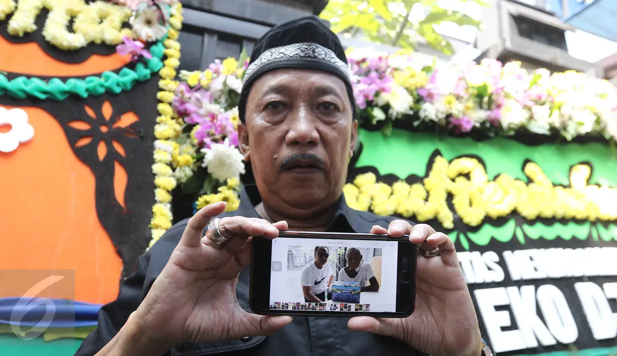 Komedian Doyok menujukkan foto Alm Eko Koeswoyo alias Eko DJ kepada wartawan kawasan Pondok Kelapa, Jakarta, Selasa (28/3). Eko DJ meninggal dunia dalam usia 65 tahun. (Liputan6.com/Herman Zakharia)