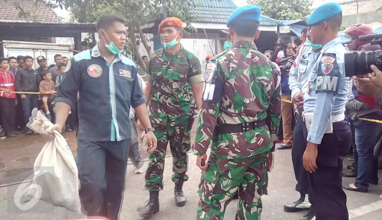Petugas melakukan evakuasi serpihan pesawat Super Tucano yang jatuh menimpa rumah warga di Malang, Jawa Timur, (10/2). Tiga korban adalah Mayor Penerbang IFI, Copilot Saiful dan istri pemilik rumah, Ny Pujianto. (Liputan6.com/Zainul Arifin)