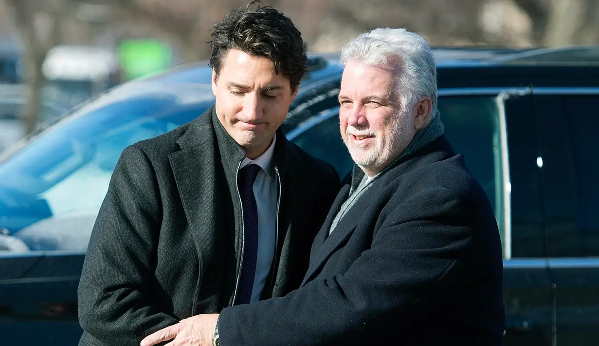 PM Kanada, Justin Trudeau menyapa Wali Kota Quebec, Philippe Couillard setibanya di Montreal Olympic, Kamis (2/2). PM Kanada menghadiri upacara pemakaman tiga dari enam korban penembakan di Masjid Quebec. (Graham Hughes/The Canadian Press via AP)