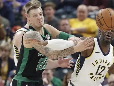 Pemain Boston Celtics, Daniel Theis (tengah) berebut bola dengan pemain Indiana Pacers, Damien Wilkins (kanan) pada lanjutan NBA basketball game di Bankers Life Fieldhouse, Indianapolis, (25/11/2017). Boston Celtics menang 108-98. (AP/Darron Cummings)
