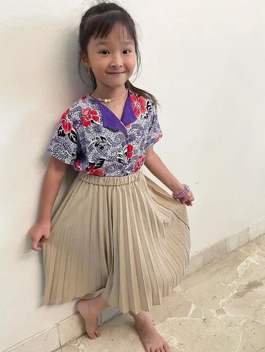 Padu padan kemeja motif batik dengan rok plisket bikin look Thalia putri Sarwenda dan Ruben Onsu terlihat manis. (Instagram/thaliaputrionsu).
