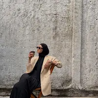 OOTD ngopi Paula terlihat kece dengan paduan t-shirt, rok panjang, dan blazer nude. Ditutup dengan hijab lilit dan sunglasses [@paula_verhoeven]