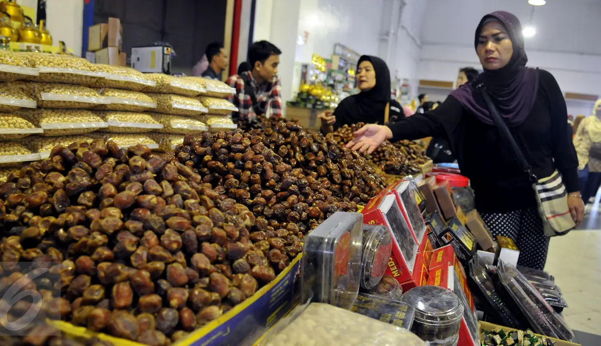 Calon pembeli memilih kurma yang dijajakan di salah satu kios pasar Tanah Abang, Jakarta, Jumat (10/6). Menurut pedagang, penjualan kurma di bulan Ramadan mengalami peningkatan hingga dua kali lipat dibandingkan hari biasanya. (Liputan6.com/Johan Tallo)