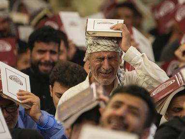 Seorang muslim Syiah Irak menangis saat berdoa pada malam lailatulqadar selama bulan suci Ramadhan di makam Imam Moussa al-Kadhim, Baghdad, Irak, Selasa (11/4/2023). (AP Foto/Hadi Mizban)