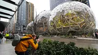 Alex Crook mengambil gambar kantor Amazon bernuansa hutan hujan yang baru, The Spheres, di Seattle, Senin (29/1). Di dalamnya dibuat seperti taman besar dengan ruang-ruang terbuka, sehingga tidak ada ruang konferensi yang tertutup. (AP/Ted S. Warren)