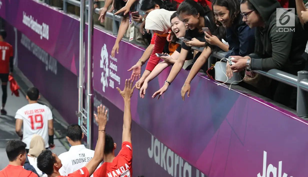 Suporter memberi salam dukungan kepada pemain bola voli putra Indonesia meski kalah dalam babak perempat final bola voli putra Asian Games 2018 di Volley Indoor Jakarta, Selasa (28/8). (Liputan6.com/Fery Pradolo)