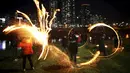 Sejumlah anak memutarkan kaleng berisi kayu yang dibakar jelang perayaan "Jeongwol Daeboreum"di sebuah taman di Seoul, Korea Selatan, Minggu (21/2). Tarian api ini merupakan bagian dari perayaan Imlek ala Korea. (REUTERS/Kim Hong-Ji)