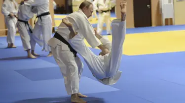 Presiden Rusia Vladimir Putin menjatuhkan anggota tim judo nasional Rusia saat sesi latihan di Sochi, Rusia, (8/1/2016). (REUTERS/Alexei Nikolsky/Sputnik/Kremlin)