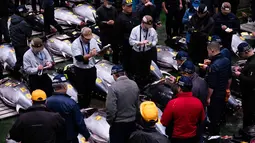 Acara lelang yang digelar secara tradisional ini diadakan pada setiap awal tahun baru di bulan Januari. Tampak dalam foto, para pedagang grosir dan pembeli berpartisipasi dalam lelang tahunan “Tahun Baru” di pasar ikan Toyosu di Tokyo, Senin, 5 Januari 2026. (AP Photo/Louise Delmotte)