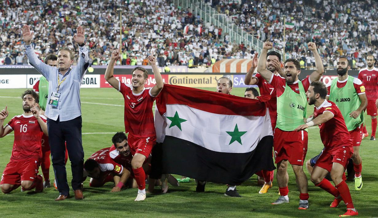 Para pemain Suriah berpesta usai menahan imbang Iran 2-2 pada laga kualifikasi Piala Dunia 2018 di Stadion Azadi, Taheran, Selasa (5/9/2017). Finis urutan tiga grup A, Suriah lolos ke babak playoff untuk menantang Australia. (AFP/Atta Kenare)