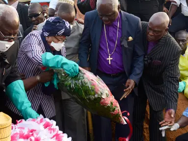 Presiden Sierra Leone Ernest Bai Koroma (kedua kiri) dan Presiden Liberia Ellen Johnson Sirleaf (tengah) meletakan bunga saat menghadiri pemakaman korban longsor di pemakaman Paloko, Waterloo, Sierra Leone,(17/8). (AFP Photo/Seyllou)