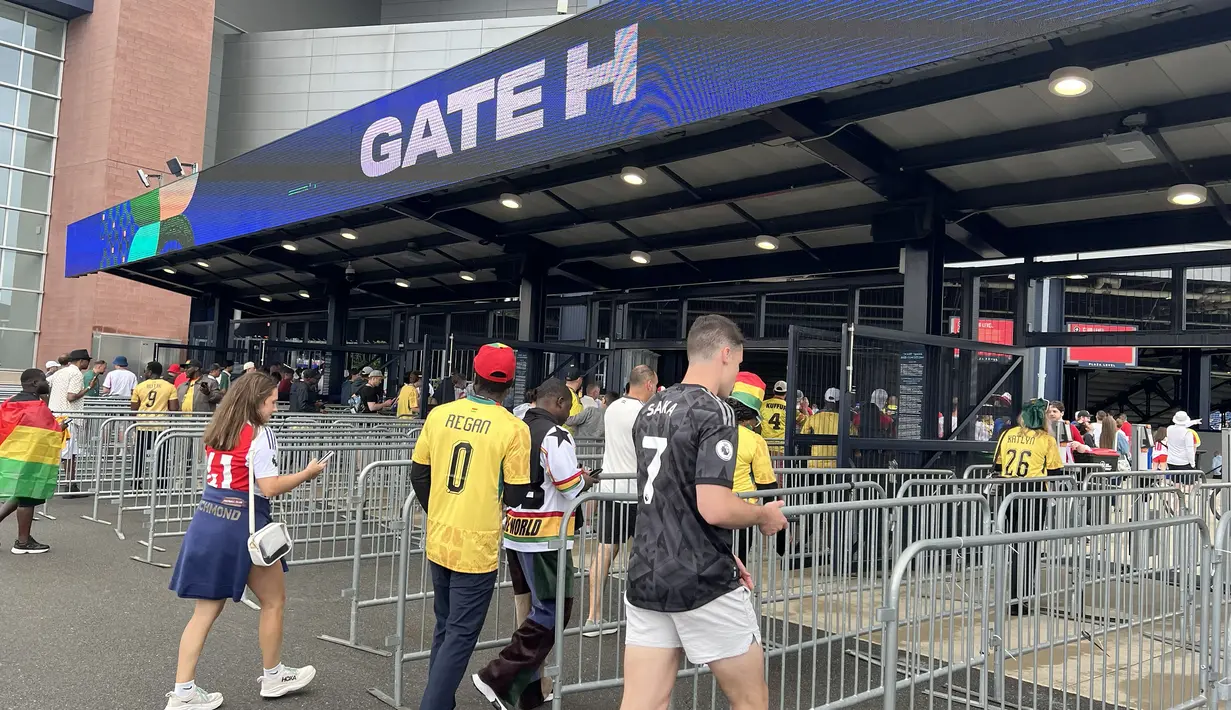 Suporter Inggris dan Ghana mengantre di pintu masuk Gillette Stadium, Foxborough, Boston, AS, Senin (23/6/2026). Para pendukung kedua tim menjalani pemeriksaan keamanan sebelum memasuki stadion untuk menyaksikan laga fase grup Piala Dunia 2026. (KLY Sports/Hery Kurniawan)