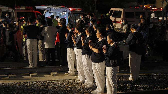 Kelompok Buddhis berdoa di lokasi tergelincirnya kereta Puyuma Express di Yilan, Taiwan, Minggu (21/10). Saksi mengatakan bahwa mereka mendengar suara dentuman keras kemudian melihat percikan api serta asap sebelum kecelakaan. (Daniel M Shih/AFP)
