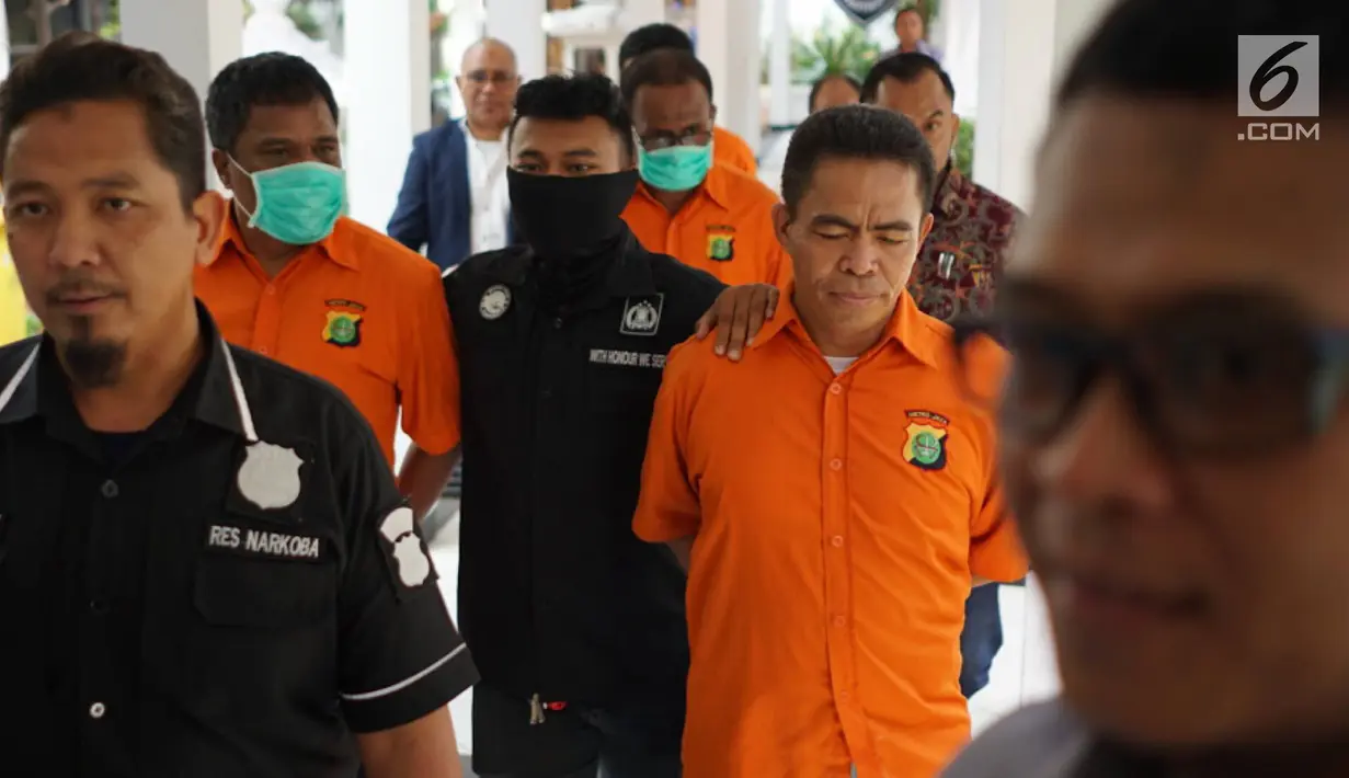 Tokoh pemuda Umar Kei (kanan) digelandang petugas saat rilis kasus narkotika jenis sabu di Polda Metro Jaya, Jakarta, Kamis (15/8/2019). Polisi menyita 2,91 gram sabu, senjata api revolver dengan enam butir peluru, alat hisap sabu, sebuah mobil, serta empat unit HP. (Liputan6.com/Immanuel Antonius)