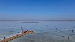 Foto dari udara pada 23 September 2020 ini memperlihatkan para turis yang berkunjung ke Danau Garam Caka di Wilayah Wulan, Provinsi Qinghai, China barat laut. Danau garam hasil kristalisasi alami di ketinggian 3.100 meter itu dikenal dengan sebutan "cermin langit". (Xinhua/Zhang Long)