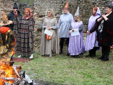 Sejumlah orang menggelar ritual sihir di acara Walpurgis Night atau Witches Night di Vilnius, Lithuania, Senin (1/5). Orang-orang yang hadir mengenakan atribut layaknya para penyihir. (AFP PHOTO / Petras Malukas)