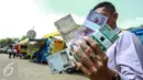 Warga menunjukkan uang pecahan Rupiah di layanan penukaran uang receh di Monas, Jakarta, Selasa (30/6). Bank Indonesia bekerjasama dengan 14 bank lainnya membuka loket penukaran uang pecahan kecil sejak 17 Juni-15 Juli 2015. (Liputan6.com/Faizal Fanani)